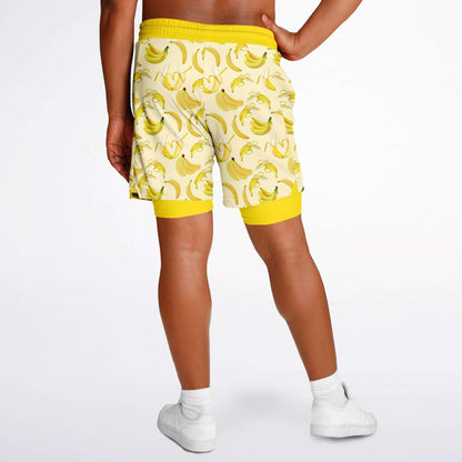 Men's 2-in-1 Shorts. These fun yellow workout shorts feature a banana design. Shorts have a drawstring, zip up side pockets, and hidden phone pocket.