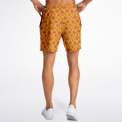 Men’s shorts featuring a pizza design of pizza pies and pizza slices on a yellow/orange background with two side pockets.