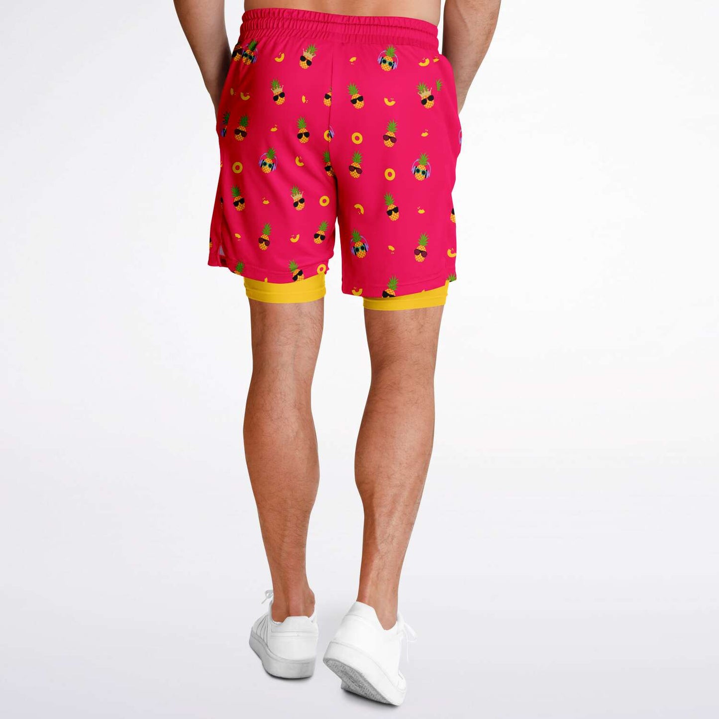 Men's 2-in-1 Shorts. These fun shorts feature a pink background with pineapples wearing a variety of sunglasses. Shorts have a black drawstring and zip up pockets.