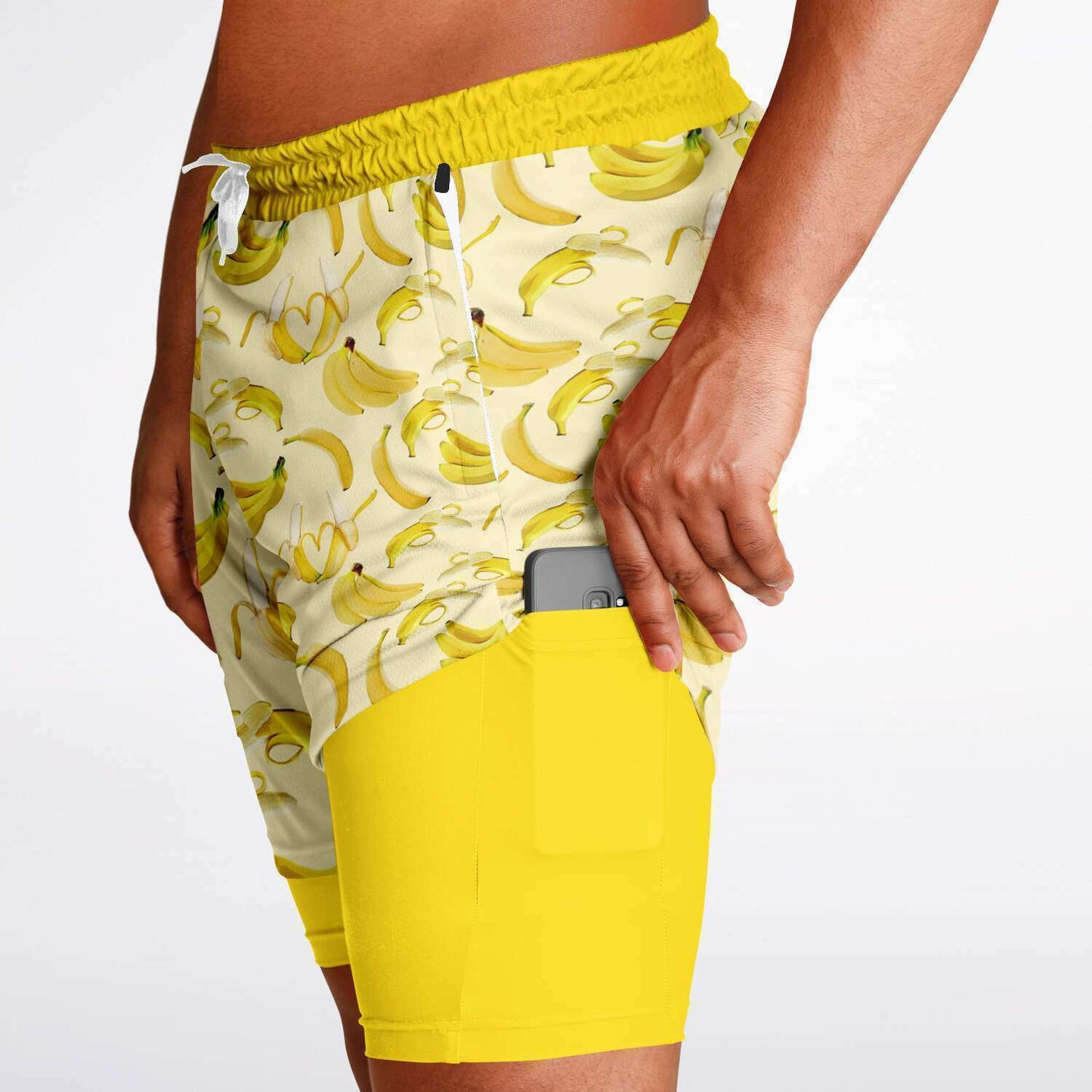 Men's 2-in-1 Shorts. These fun yellow workout shorts feature a banana design. Shorts have a drawstring, zip up side pockets, and hidden phone pocket.