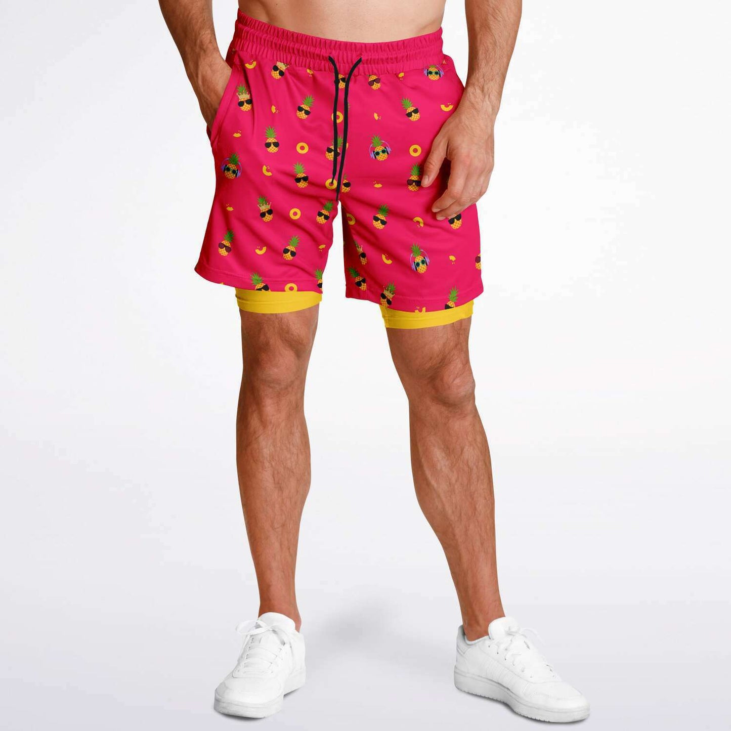 Men's 2-in-1 Shorts. These fun shorts feature a pink background with pineapples wearing a variety of sunglasses. Shorts have a black drawstring and zip up pockets.